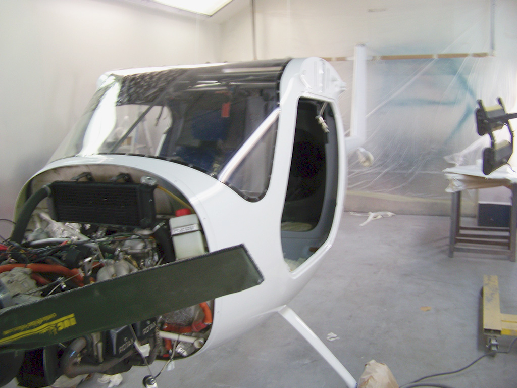 Un hélicoptère blanc doté d'un petit moteur, illustrant sa conception compacte et ses capacités aéronautiques.