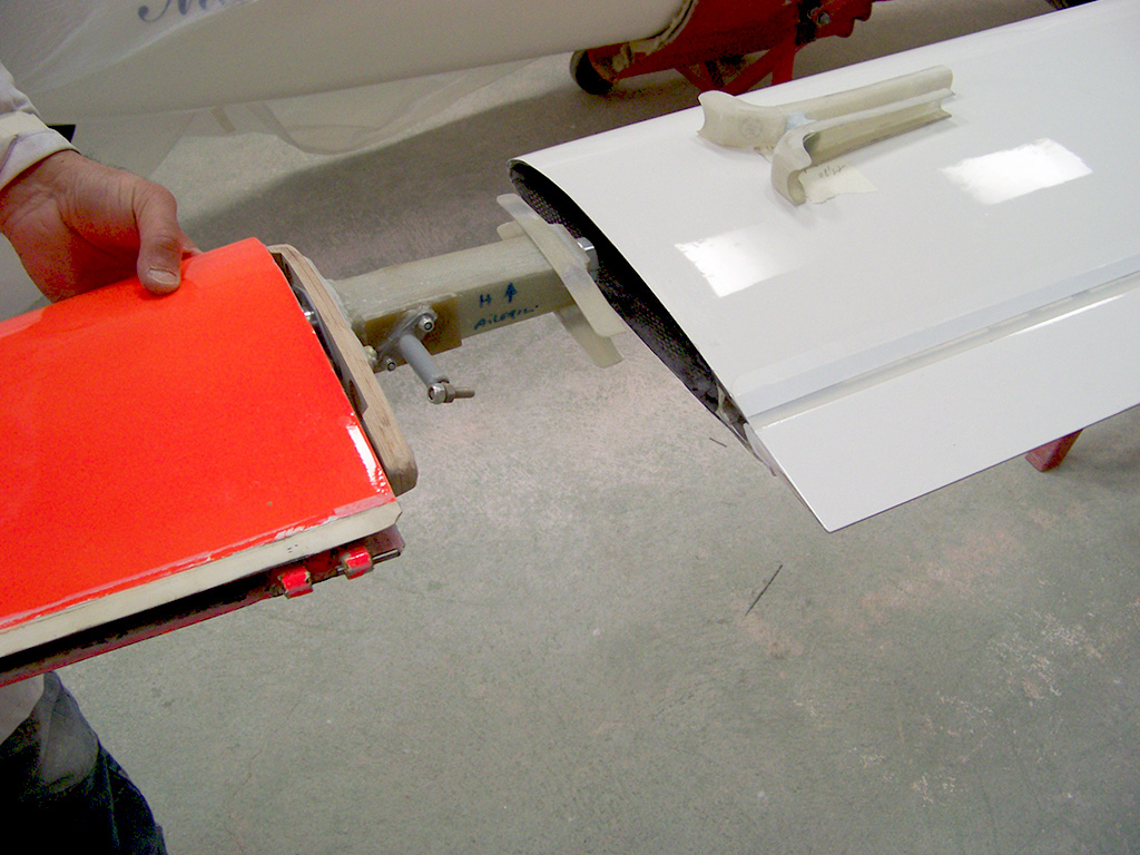 Une planche de surf est en cours d'assemblage dans un atelier, mettant en valeur le savoir-faire et les outils nécessaires à sa fabrication.