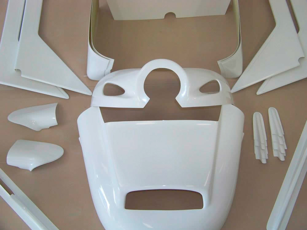 Un petit avion est immobile dans un hangar, ailes repliées et porte entrouverte.